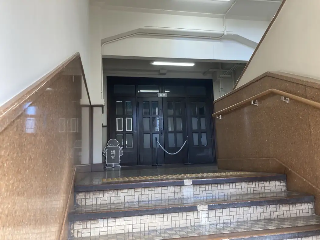 Staircase and wooden doors marked auditorium in an old Kyoto Japanese school building