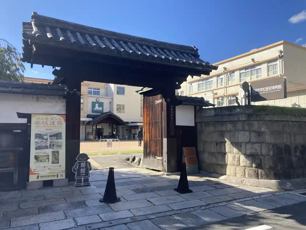 Historic tile-roofed gate leading into Kyoto Municipal Museum of School History, with the former school buildings behind it