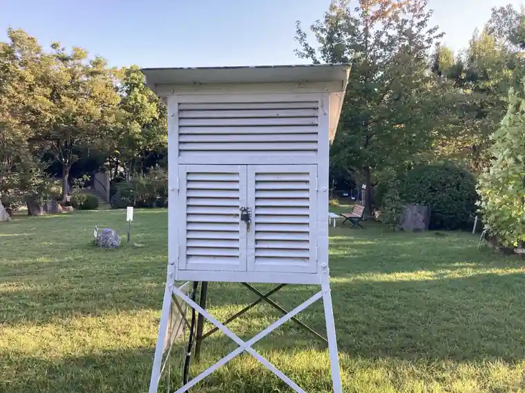 White louvered weather observation shelter standing in the garden